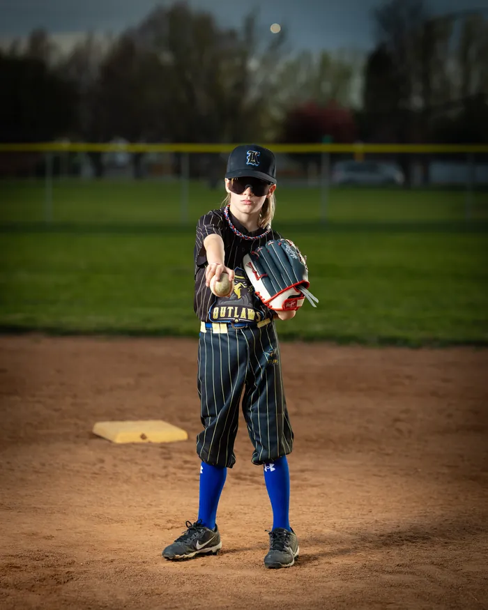Kuna Outlaws youth baseball player holding out a glove and ball on the infield, Kuna Idaho
