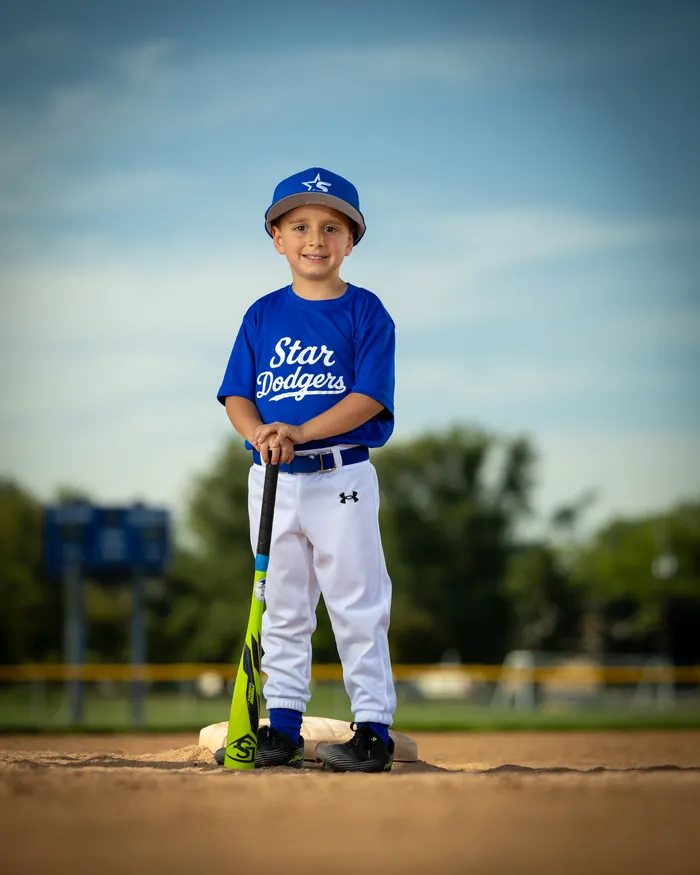 Star Dodgers tee ball player smiling on home plate with a bat, Star Idaho