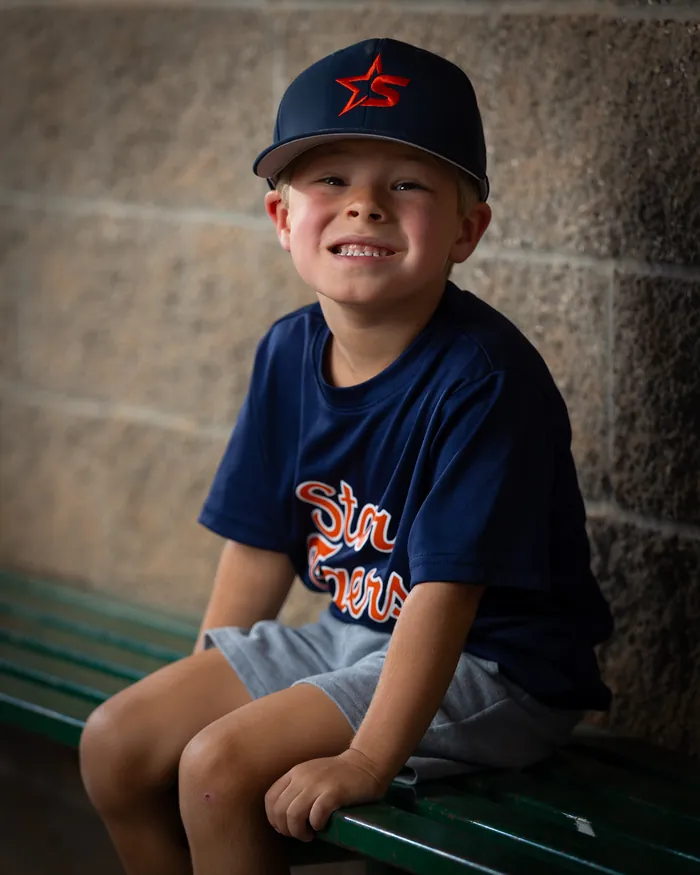 Star Tigers youth baseball player seated on the dugout bench, Star Idaho