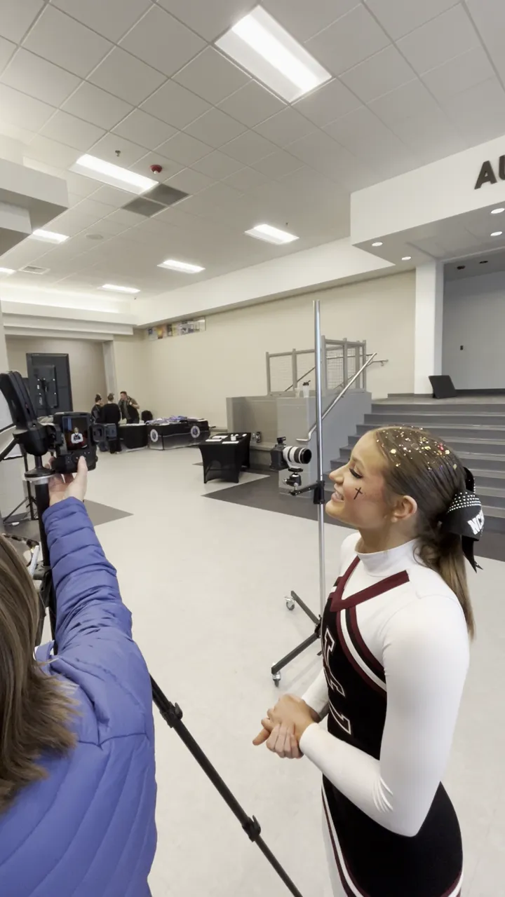 Cheerleader reacting to her portrait on the camera during an on-site photo session