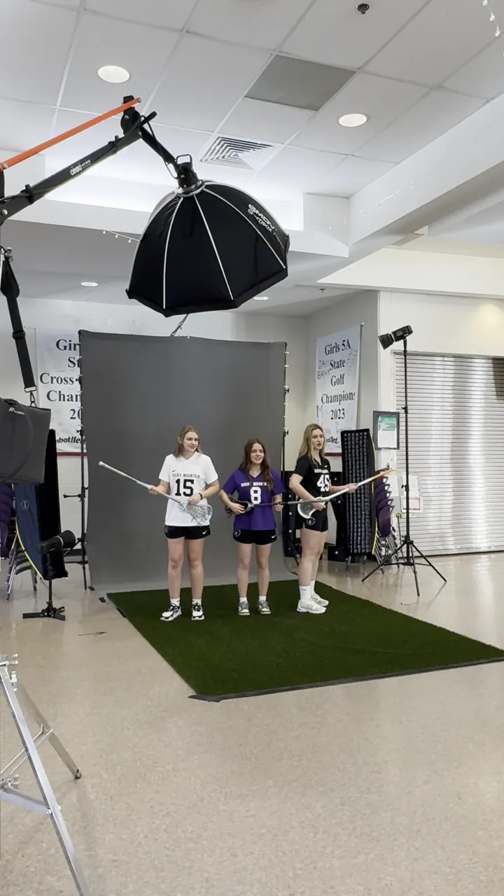 Behind the scenes at a Rocky Mountain High School girls lacrosse media day, studio lighting set up on site