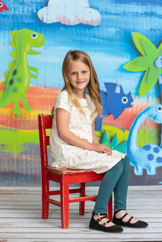 Elementary school girl in polka dot dress seated for photo day portrait - school photography Meridian Idaho